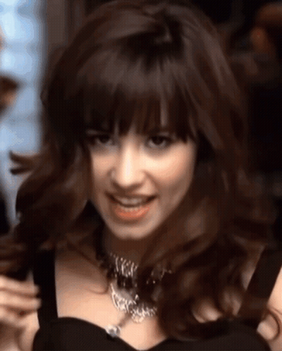 Woman In Black Dress And Necklace Smiling GIF