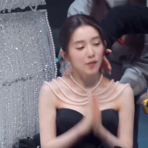 Woman In Black Dress And Pearl Necklace Praying GIF
