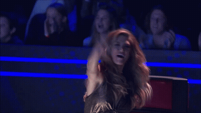 Woman In Black Dress Arms Outstretched To Crowd GIF