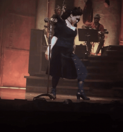 Woman In Black Dress At Microphone GIF