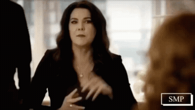 Woman In Black Dress At Table With SMP Sign GIF