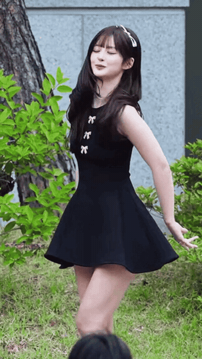 Woman In Black Dress Dancing In Grass GIF