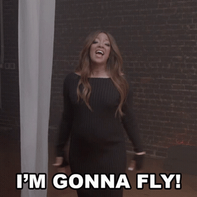 Woman In Black Dress Flying With Arms Up GIF