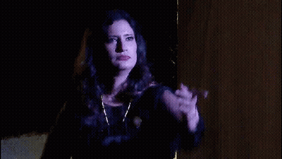 Woman In Black Dress Hand Up In Dark GIF