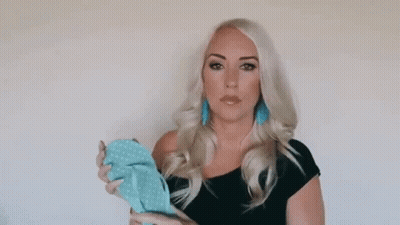 Woman In Black Dress Holding Blue Item GIF