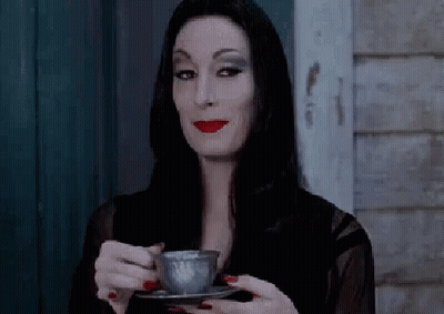 Woman In Black Dress Holding Coffee Cup GIF