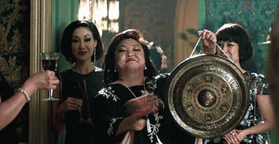 Woman In Black Dress Holding Gong With Chinese Writing GIF