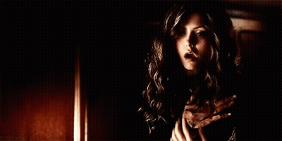 Woman In Black Dress Holding Hands To Chest GIF