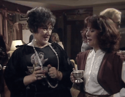 Woman In Black Dress Holding Silver Cup GIF