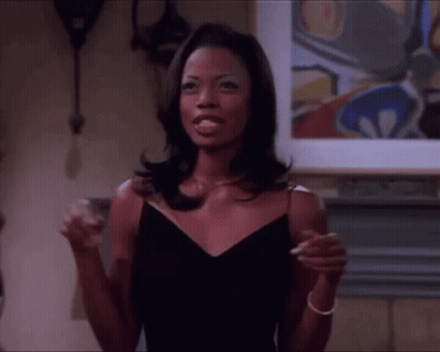 Woman In Black Dress In Front Of Fireplace And Painting GIF