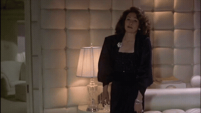 Woman In Black Dress In Front Of Lamp In Bedroom GIF