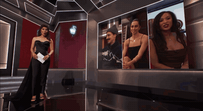 Woman In Black Dress In Front Of Photo Wall GIF