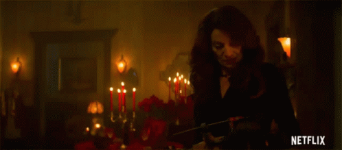 Woman In Black Dress In Room With Candles GIF