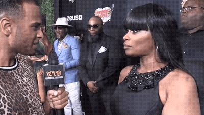 Woman In Black Dress Interviewed By Man With WTB Microphone GIF