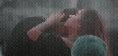 Woman In Black Dress Kissing Man On Lap GIF