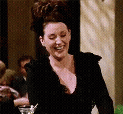 Woman In Black Dress Laughing Holding Martini GIF