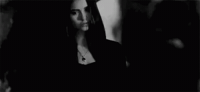 Woman In Black Dress Next To Man In Black And White GIF