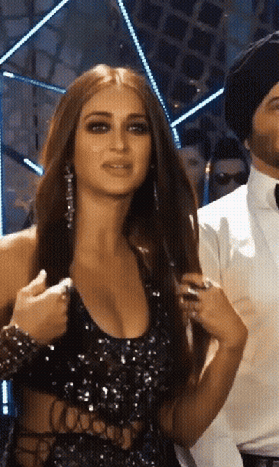 Woman In Black Dress Next To Man In Black Hat GIF