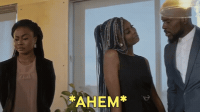 Woman in Black Dress Next to Man in Suit Saying Ahem