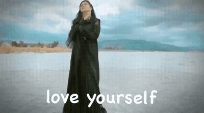 Woman In Black Dress On Beach Saying Love Yourself GIF