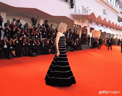 Woman In Black Dress On Red Carpet With Photographers GIF