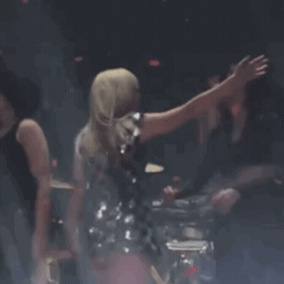 Woman In Black Dress On Stage With Arm Outstretched GIF