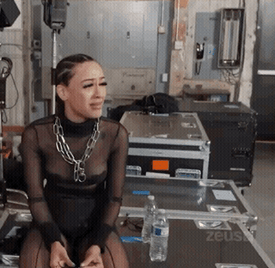 Woman In Black Dress On Table With Zeus Case And Water GIF