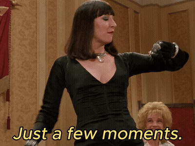 Woman In Black Dress Saying Just A Few Moments GIF