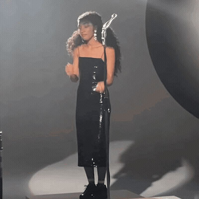 Woman In Black Dress Singing Into Microphone GIF