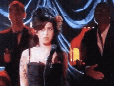 Woman In Black Dress Singing Into Microphone GIF