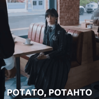 Woman In Black Dress Sitting At Table GIF