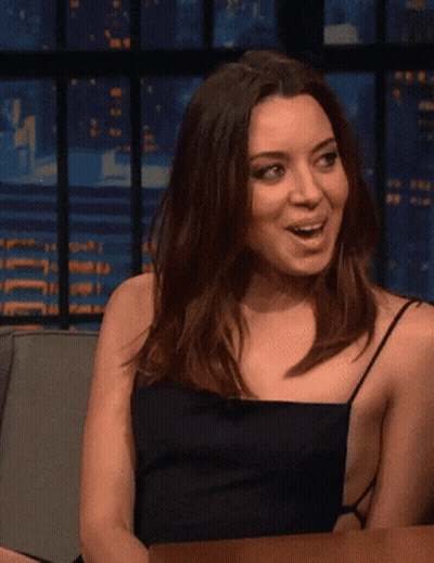 Woman In Black Dress Sitting At Table With Mouth Open GIF