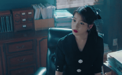 Woman In Black Dress Sitting In Chair In Office GIF