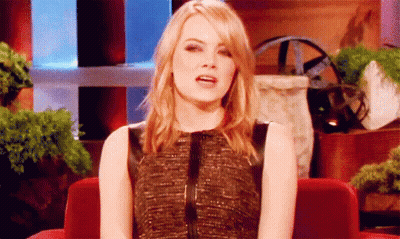 Woman In Black Dress Sitting In Red Chair With Mouth Open GIF