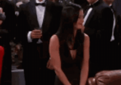 Woman In Black Dress Sitting With Man In Tuxedo GIF