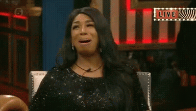 Woman In Black Dress Sitting With Mouth Open And Live Sign GIF