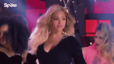 Woman In Black Dress Standing Before Crowd GIF