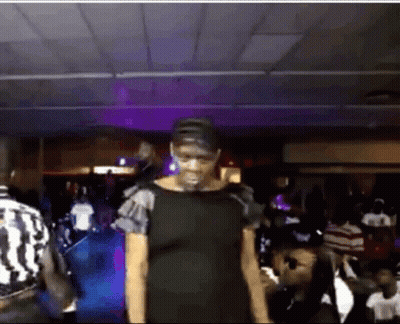 Woman In Black Dress Standing Before Crowd GIF