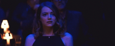 Woman In Black Dress Standing In Dark Room Before Group GIF