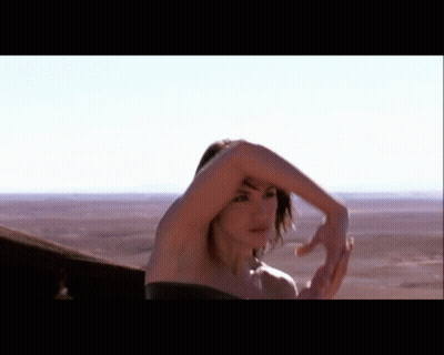 Woman In Black Dress Standing In Desert GIF