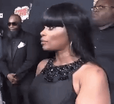 Woman In Black Dress Standing In Front Of Man In Suit And Sunglasses GIF