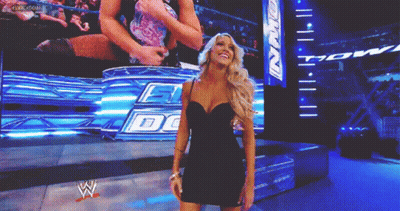 Woman In Black Dress Standing In Front Of Screen Saying DG GIF