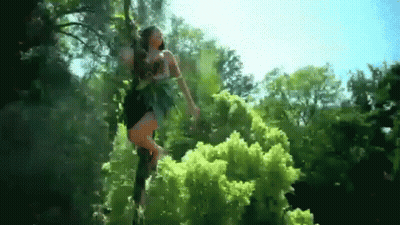 Woman In Black Dress Standing In Woods GIF