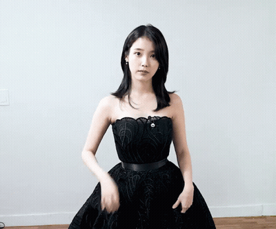 Woman In Black Dress Standing On Wooden Floor GIF