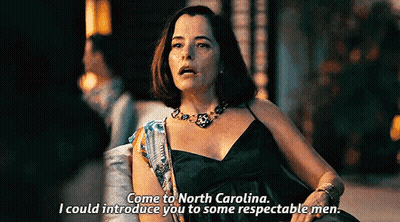 Woman In Black Dress Talking To Man In Dark Room GIF