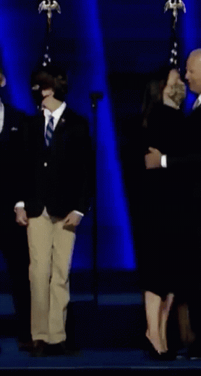 Woman In Black Dress With Fist In Air GIF
