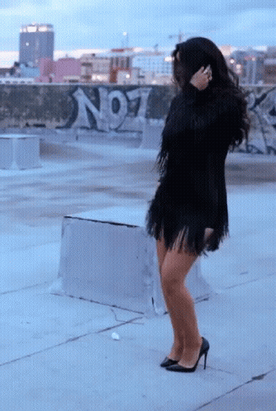 Woman In Black Fringed Dress In Front Of No1 Graffiti Wall GIF