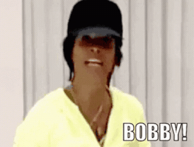 Woman In Black Hat And Yellow Shirt Saying Bobby GIF