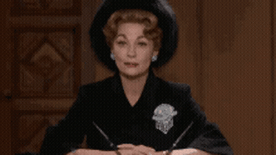 Woman In Black Hat Sitting At Table GIF