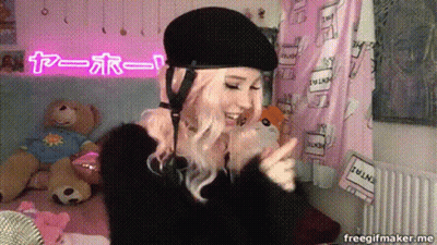 Woman In Black Helmet In Front Of Pink I Love You Sign GIF